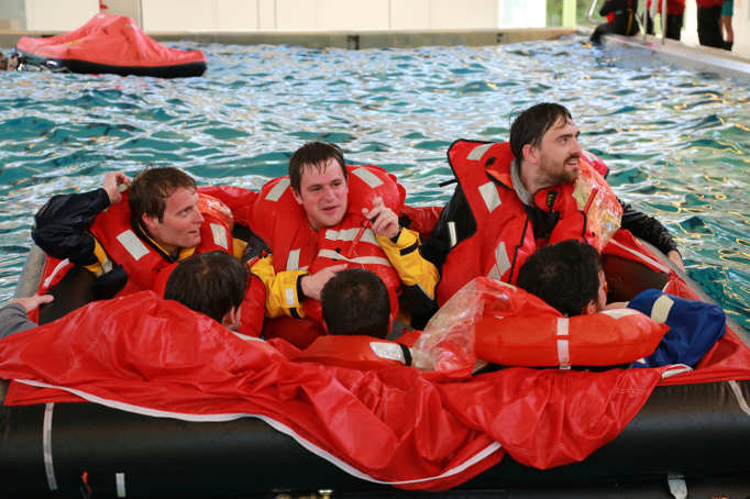 Junge Männer in Rettungsinsel im Schwimmbad